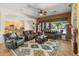 Spacious living room featuring a ceiling fan, plush seating, a decorative rug, and an open floor plan leading to the kitchen at 2222 W Morse Ct, Anthem, AZ 85086
