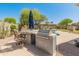 Outdoor kitchen featuring a built-in grill, bar seating and backyard views, perfect for entertaining at 2222 W Morse Ct, Anthem, AZ 85086