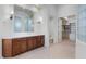 Bright bathroom with dual sinks, tile flooring, decorative sconces and access to a walk-in closet at 22463 N 54Th St, Phoenix, AZ 85054