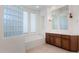Elegant bathroom with glass block wall, dual sink vanity, tile flooring and soaking tub at 22463 N 54Th St, Phoenix, AZ 85054