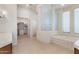 Bright bathroom featuring tile flooring, a glass block wall, and soaking tub at 22463 N 54Th St, Phoenix, AZ 85054