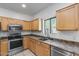 Well-lit kitchen featuring wood cabinets, modern appliances, and a large window overlooking the greenery of the neighborhood at 2250 E Deer Valley Rd # 24, Phoenix, AZ 85024