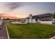 Spacious backyard at dusk with lush lawn, pool, and solar panels on roof at 2259 E Ivy St, Mesa, AZ 85213
