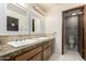 Bathroom with granite countertops, double sinks, decorative mirrors, and access to a second toilet at 2259 E Ivy St, Mesa, AZ 85213