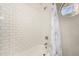 Clean bathroom featuring a shower-tub combination, stylish curtain, and white subway tile walls at 2259 E Ivy St, Mesa, AZ 85213