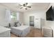 Bright bedroom featuring stylish bed, wood floors, ceiling fan, a large window, and decor at 2259 E Ivy St, Mesa, AZ 85213
