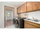 Bright laundry room equipped with modern washer and dryer, sink, and plenty of storage cabinets at 2259 E Ivy St, Mesa, AZ 85213