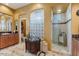 Luxurious bathroom with dual vanities, a glass block partition, and a fully-tiled walk-in shower at 25943 N 84Th Dr, Peoria, AZ 85383