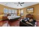Large bedroom showcases hardwood floors, a decorative ceiling fan and three windows with plantation shutters at 25943 N 84Th Dr, Peoria, AZ 85383