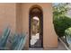 Close up of an arched entry gate with a view of the courtyard beyond, framed by desert landscaping at 25943 N 84Th Dr, Peoria, AZ 85383