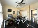Well-equipped workout room featuring a treadmill, exercise machine, ceiling fan and mounted television at 25943 N 84Th Dr, Peoria, AZ 85383