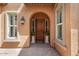 Elegant front door with sidelights, arched entryway, and manicured landscaping adding curb appeal at 25943 N 84Th Dr, Peoria, AZ 85383