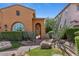 Charming front of house with desert landscaping, stone pathway, arched entry gate, and decorative window at 25943 N 84Th Dr, Peoria, AZ 85383