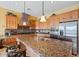 Spacious kitchen featuring wood cabinetry, granite countertops, stainless steel appliances, and a functional island at 25943 N 84Th Dr, Peoria, AZ 85383