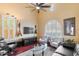 Cozy living room features a ceiling fan, plantation shutters, and comfortable seating arrangement at 25943 N 84Th Dr, Peoria, AZ 85383