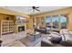 Inviting living room with tile floors, fireplace, large windows, and access to the outdoor pool at 25943 N 84Th Dr, Peoria, AZ 85383