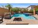 Backyard oasis with a sparkling pool, spa, fire pit, and lush landscaping for outdoor enjoyment at 25943 N 84Th Dr, Peoria, AZ 85383