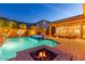 Inviting backyard oasis with pool, spa, lush landscaping, fire pit, and privacy fence at 25943 N 84Th Dr, Peoria, AZ 85383