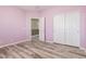 Bedroom with painted walls, wood-look floors, closet and entry door at 3133 N Medallion Ct, Casa Grande, AZ 85122