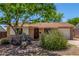 Charming single-story home with mature landscaping and unique desert accents in the front yard at 355 E Fillmore St, Tempe, AZ 85288