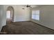 An expansive living room features a ceiling fan, neutral carpet, and an archway to another room at 3601 E Taro Ln, Phoenix, AZ 85050