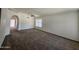 Spacious living room with neutral carpet, white walls, a window, and an archway at 3601 E Taro Ln, Phoenix, AZ 85050