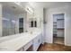 Bathroom featuring double sinks, a large mirror, walk-in closet, and a shower with glass door at 3604 W Calle Lejos --, Glendale, AZ 85310