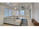 Bright living area with a modern ceiling fan, neutral sectional sofa and wood-look flooring at 3604 W Calle Lejos --, Glendale, AZ 85310