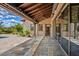 Covered back patio with stone floors, wood ceiling, chandelier, and glass doors to the home's interior at 37440 N 104Th Pl, Scottsdale, AZ 85262