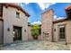 Well designed outdoor patio featuring a fireplace, custom doors, and desert landscaping at 37440 N 104Th Pl, Scottsdale, AZ 85262