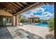 Covered back patio featuring stone floors, wood ceiling, chandelier, jacuzzi and pool at 37440 N 104Th Pl, Scottsdale, AZ 85262