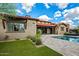 Lush backyard featuring a green lawn, desert plants and a home with a spanish tile roof at 37440 N 104Th Pl, Scottsdale, AZ 85262