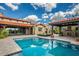 Stunning backyard with a sparkling pool, covered patio, outdoor fireplace, and lush landscaping for luxurious outdoor living at 37440 N 104Th Pl, Scottsdale, AZ 85262
