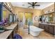 Luxurious bathroom featuring dual sinks, a soaking tub, a glass-enclosed shower, and travertine flooring at 37440 N 104Th Pl, Scottsdale, AZ 85262