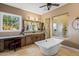 Bright bathroom featuring a soaking tub, walk-in shower, vanity, and a seating area by the window at 37440 N 104Th Pl, Scottsdale, AZ 85262