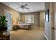 Comfortable bedroom with neutral colors, a ceiling fan, a large window, and an ensuite bathroom at 37440 N 104Th Pl, Scottsdale, AZ 85262