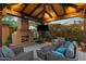This covered patio includes an outdoor fireplace, comfortable seating, and a TV perfect for outdoor entertaining at 37440 N 104Th Pl, Scottsdale, AZ 85262