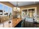 A well-lit dining room features a decorative chandelier, a wooden table, and sliding glass doors to the patio at 37440 N 104Th Pl, Scottsdale, AZ 85262