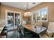 Dining room with a wooden table, decorative chairs, chandelier, and sliding glass doors to the patio at 37440 N 104Th Pl, Scottsdale, AZ 85262