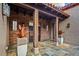 Covered entrance featuring wooden beams, brick accents, a tile floor, and decorative planters that create a cozy ambiance at 37440 N 104Th Pl, Scottsdale, AZ 85262
