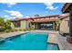 Stunning backyard pool with a Spanish tile roofed home and desert landscaping in the background at 37440 N 104Th Pl, Scottsdale, AZ 85262
