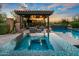 Beautiful pool area with spa, covered patio, outdoor fireplace, and seating, perfect for relaxation and entertaining at 37440 N 104Th Pl, Scottsdale, AZ 85262