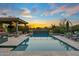 This luxurious pool and spa area is surrounded by beautiful landscaping, and a covered patio with an outdoor fireplace at 37440 N 104Th Pl, Scottsdale, AZ 85262