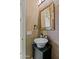Stylish powder room featuring a vessel sink, black faucet, decorative mirror, and modern wall tiles at 37440 N 104Th Pl, Scottsdale, AZ 85262