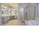Large bathroom featuring dual sinks, vanity area, soaking tub, and tiled floors at 3834 E Windsong Dr, Phoenix, AZ 85048