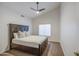 Bedroom with wood-look bed frame, ceiling fan, neutral tones, and natural light at 3834 E Windsong Dr, Phoenix, AZ 85048