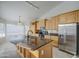 Modern kitchen features stainless steel appliances, granite countertops, and an island with sink, ideal for cooking at 3834 E Windsong Dr, Phoenix, AZ 85048