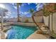 Backyard pool features palm trees, a rock waterfall, and ample space for relaxation and entertainment at 3834 E Windsong Dr, Phoenix, AZ 85048