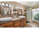 Well-lit bathroom featuring dual sinks, granite countertops and a tiled walk-in shower at 3926 W Christy Dr, Phoenix, AZ 85029