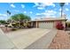 Traditional home with a two-car garage, well-maintained front lawn, desert landscaping, and a serene, cloud-filled sky at 3926 W Christy Dr, Phoenix, AZ 85029